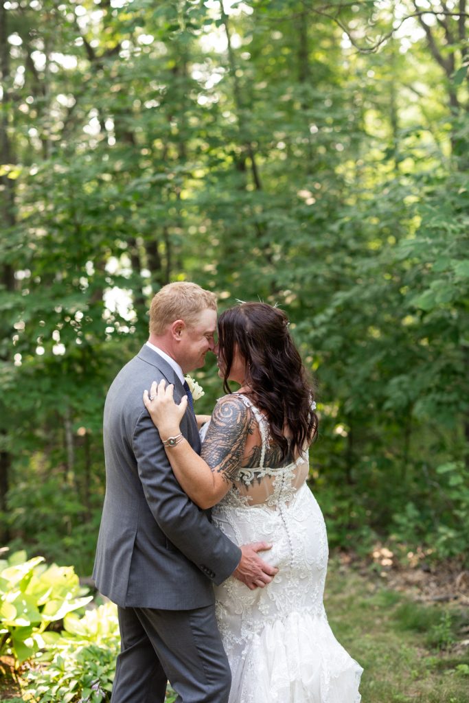 Bride and groom embracing in lakeside backyard wedding in Hayward, WI.