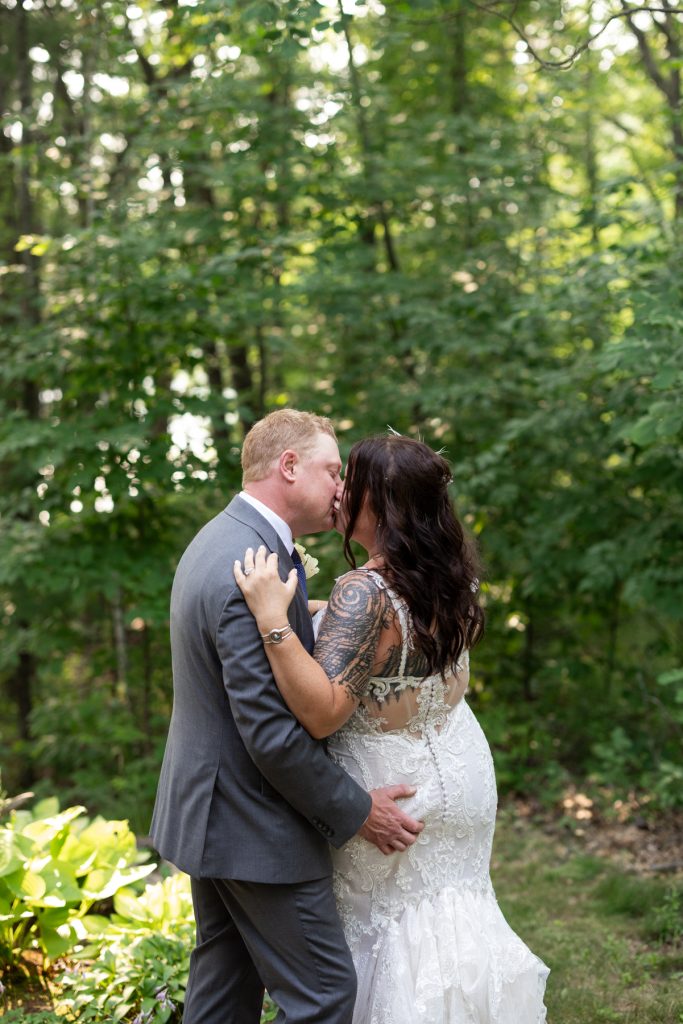 Bride and groom kissing in a lakeside backyard wedding in Hayward, WI.