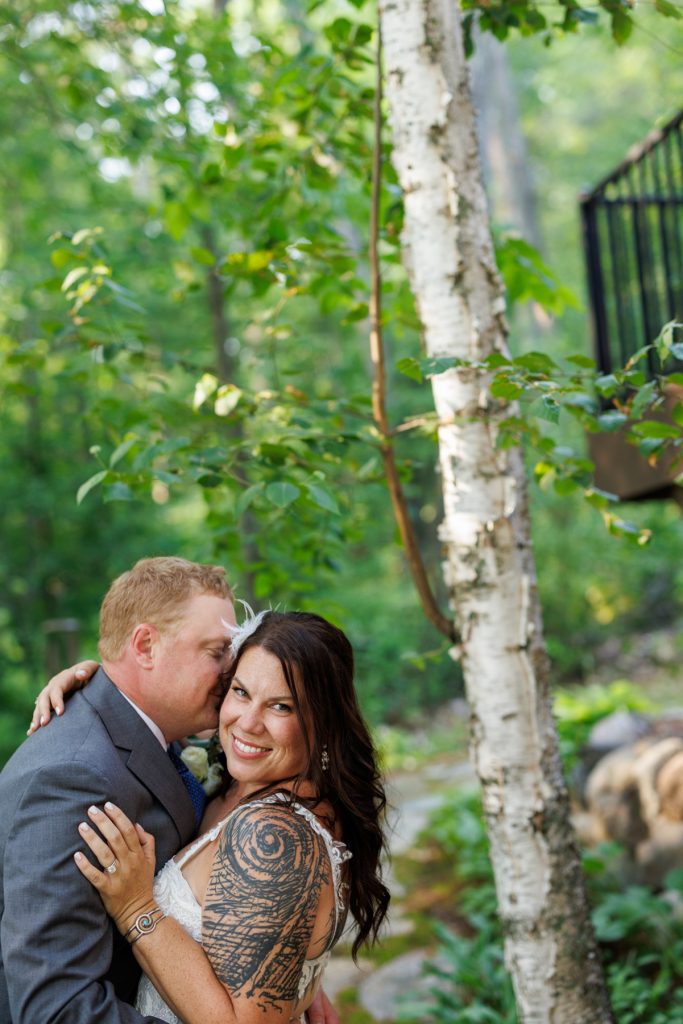 Bride and groom embracing near birch trees at Hayward, WI wedding.