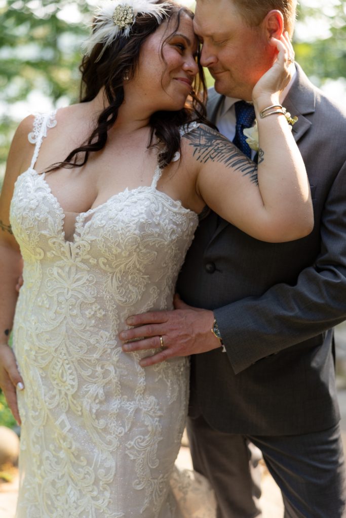 Bride and groom embracing at a lakeside wedding in Hayward, WI.