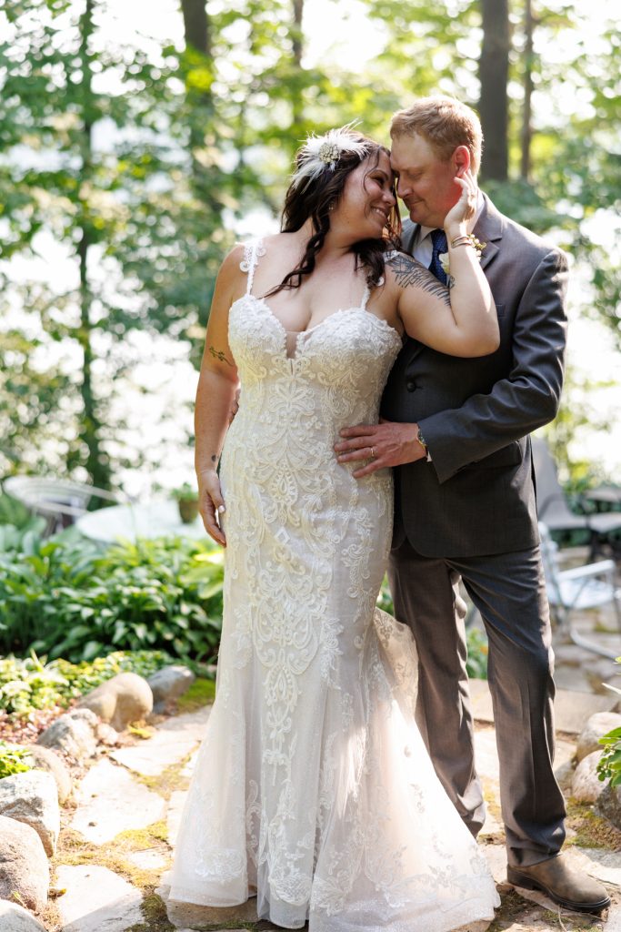 Bride and groom embracing at a lakeside cabin wedding in Hayward, WI