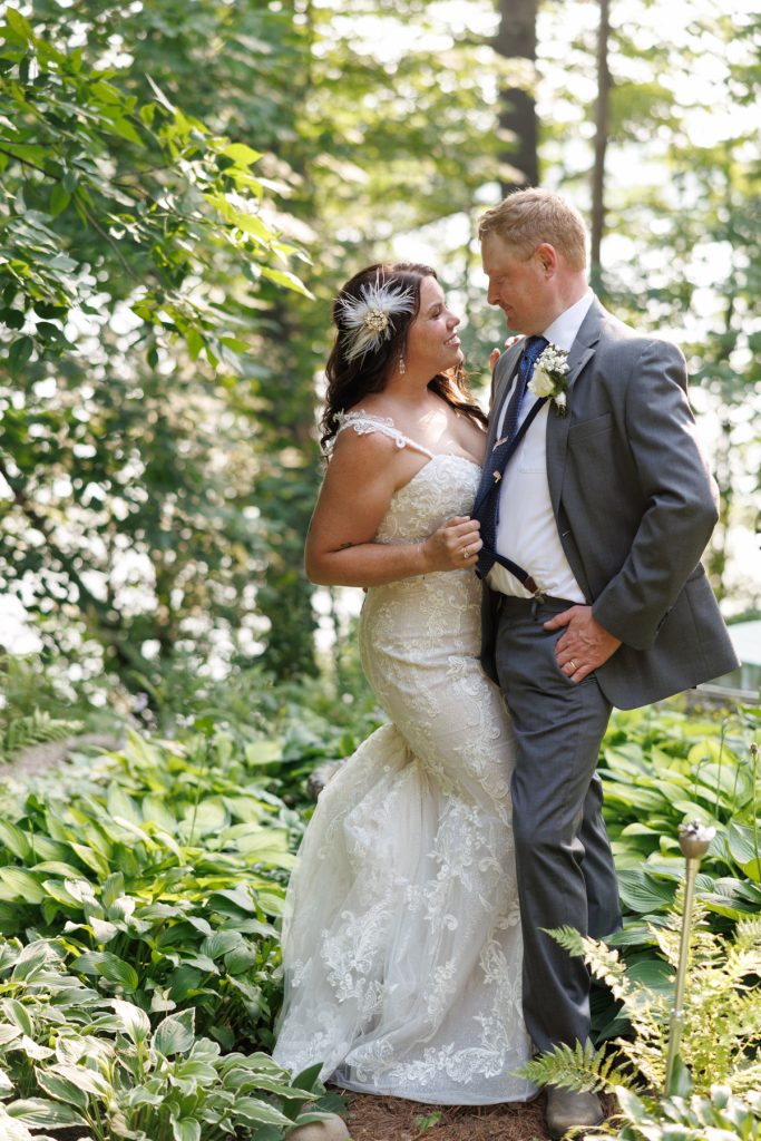 Bride and groom embracing in backyard wedding setting in Hayward, WI.