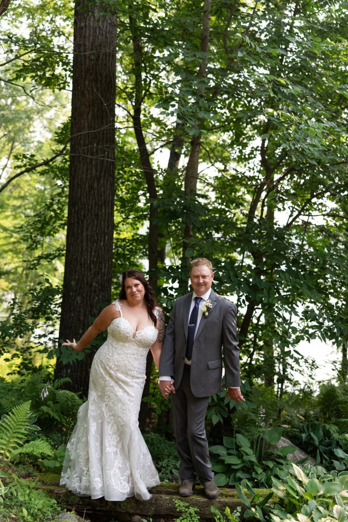 Bride and groom holding hands in Hayward, WI lakeside wedding portrait.