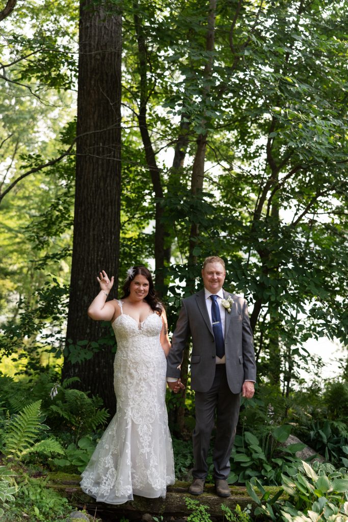 Bride and groom holding hands in a lakeside backyard wedding in Hayward, WI