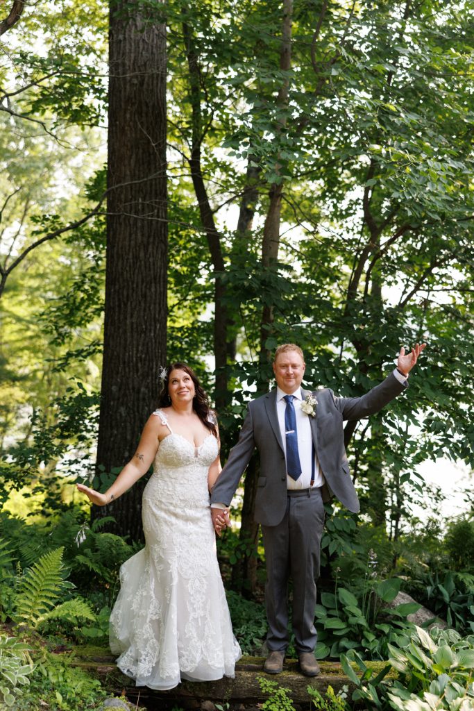 Bride and groom holding hands in Hayward, WI lakeside wedding portrait.