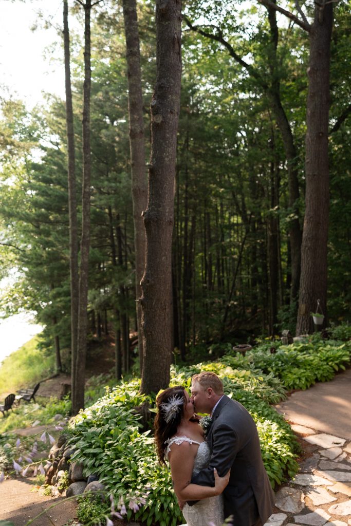 Bride and groom kissing in Hayward, WI lakeside wedding setting.