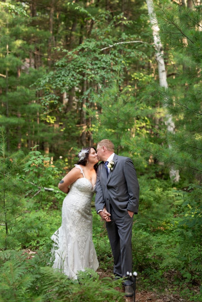 Bride and groom kissing in the woods at a Hayward, WI wedding.