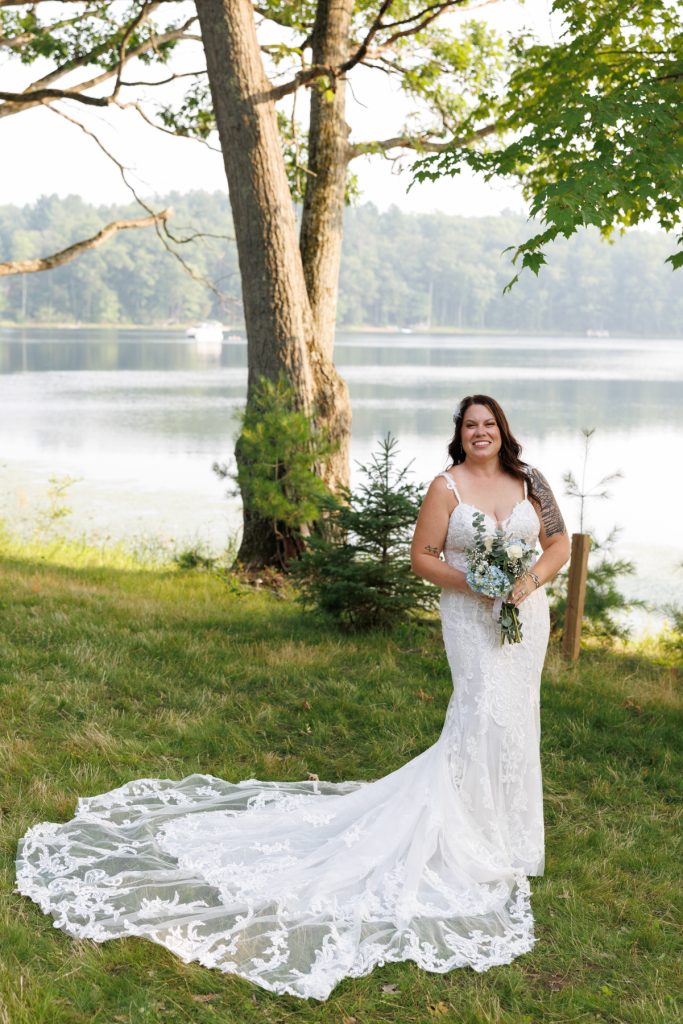 Bride in wedding dress with bouquet, lakeside ceremony in Hayward, WI