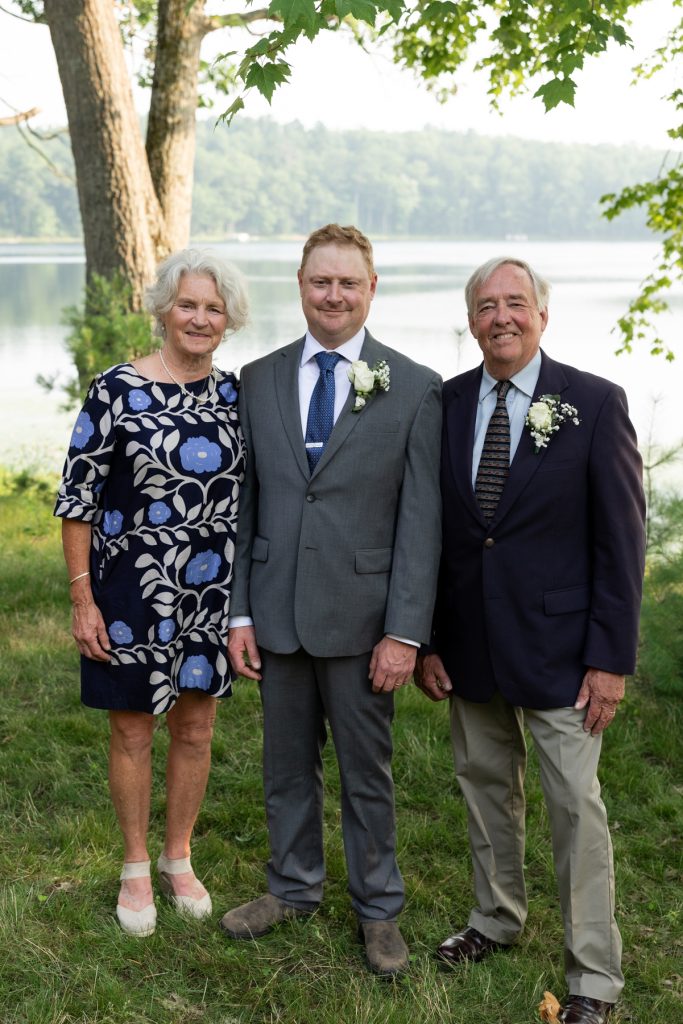 Bride's parents and groom posing for a portrait at a lakeside wedding in Hayward, WI.