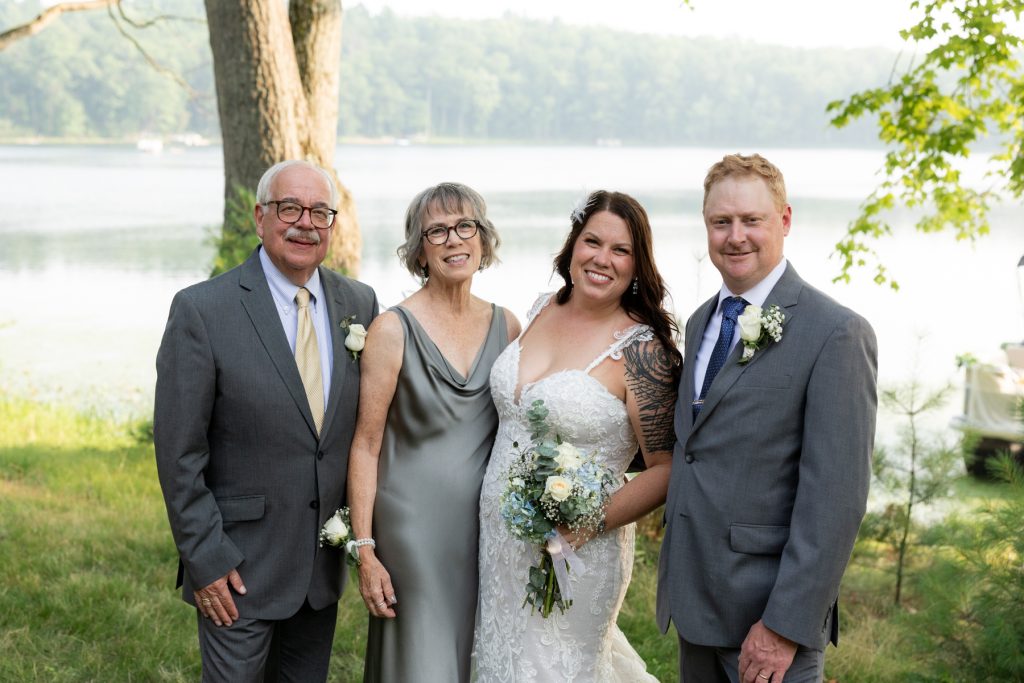 Bride and groom with parents at lake-side wedding in Hayward, WI.