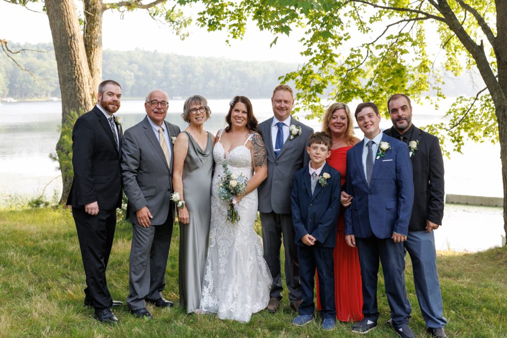 Bride and family posing for wedding portrait at lake-side cabin in Hayward, WI.