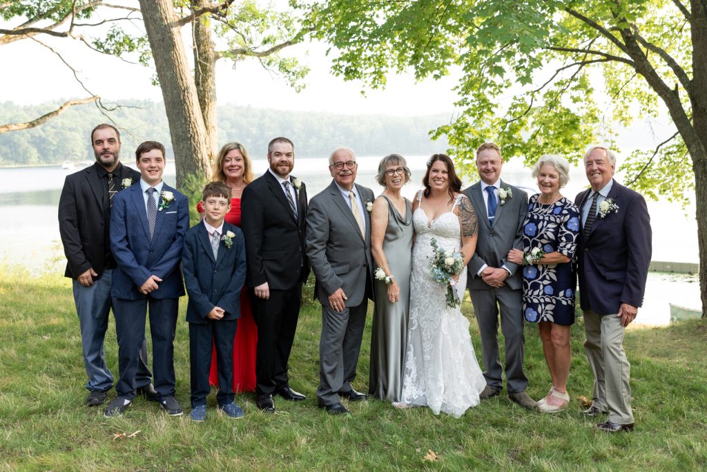 Bride and groom with family at lake-side wedding in Hayward, WI