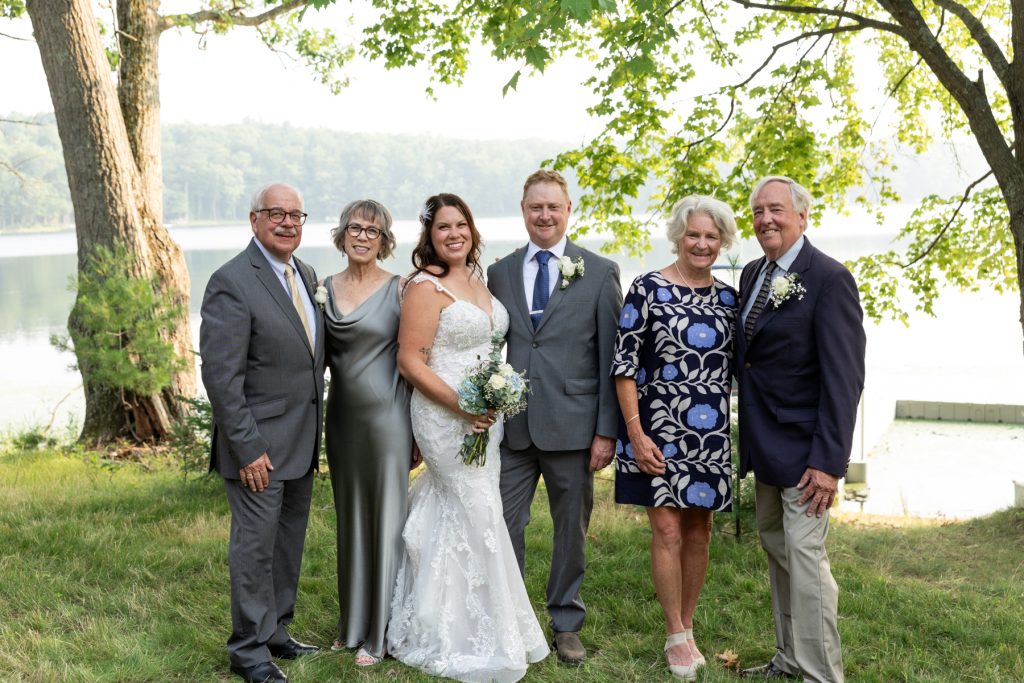 Bride and groom with family at lake-side wedding in Hayward, WI