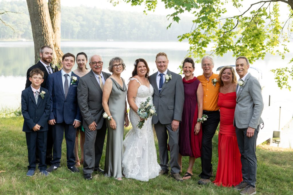 Bride and groom with family at lake-side wedding in Hayward, WI.