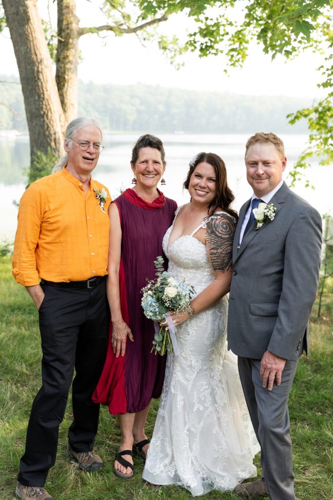 Bride and groom with family at lake-side wedding in Hayward, WI.
