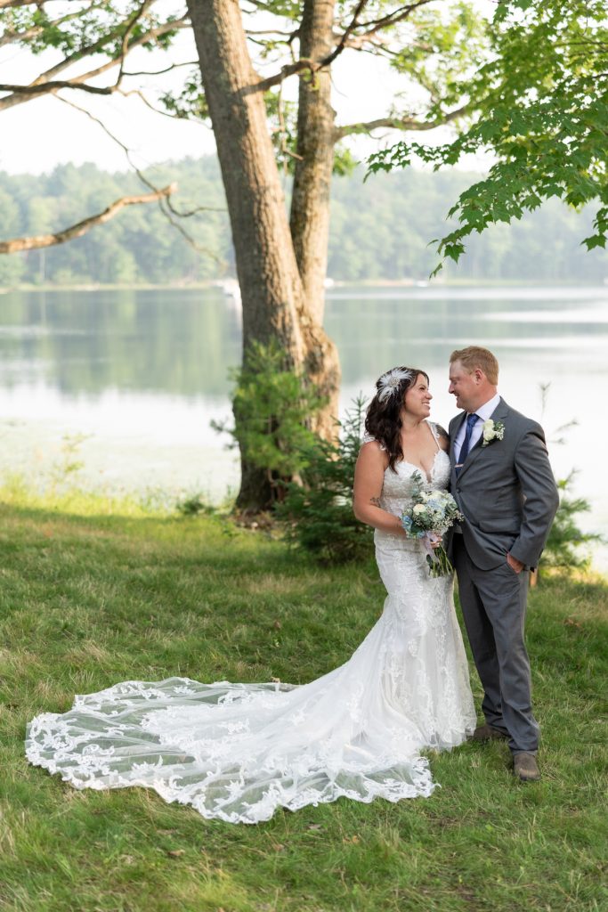 Bride and groom embracing near lake at Hayward, WI wedding.