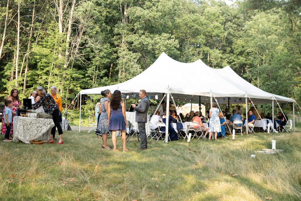 Backyard wedding reception in Hayward, WI, with tent and guests gathered.