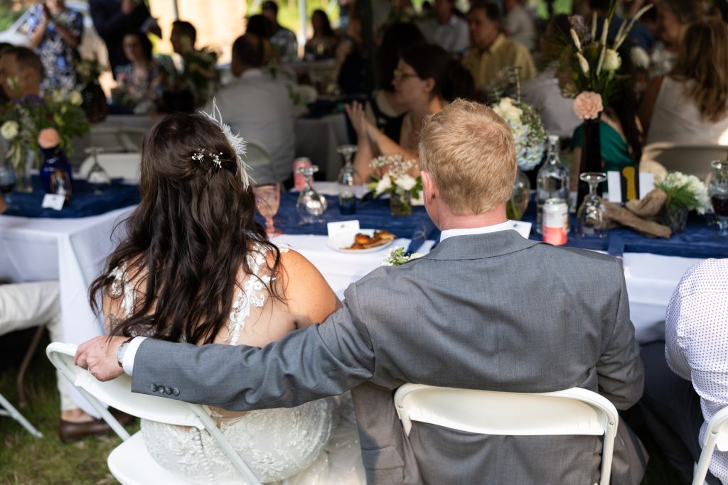Bride and groom seated at a lakeside wedding reception in Hayward, WI