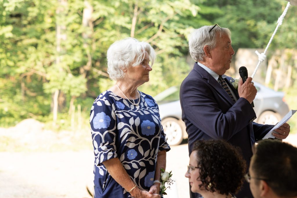 Couple listening attentively during wedding ceremony at Hayward, WI cabin.