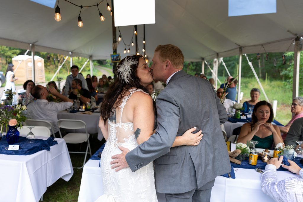 Bride and groom kissing under tent at backyard wedding in Hayward, WI