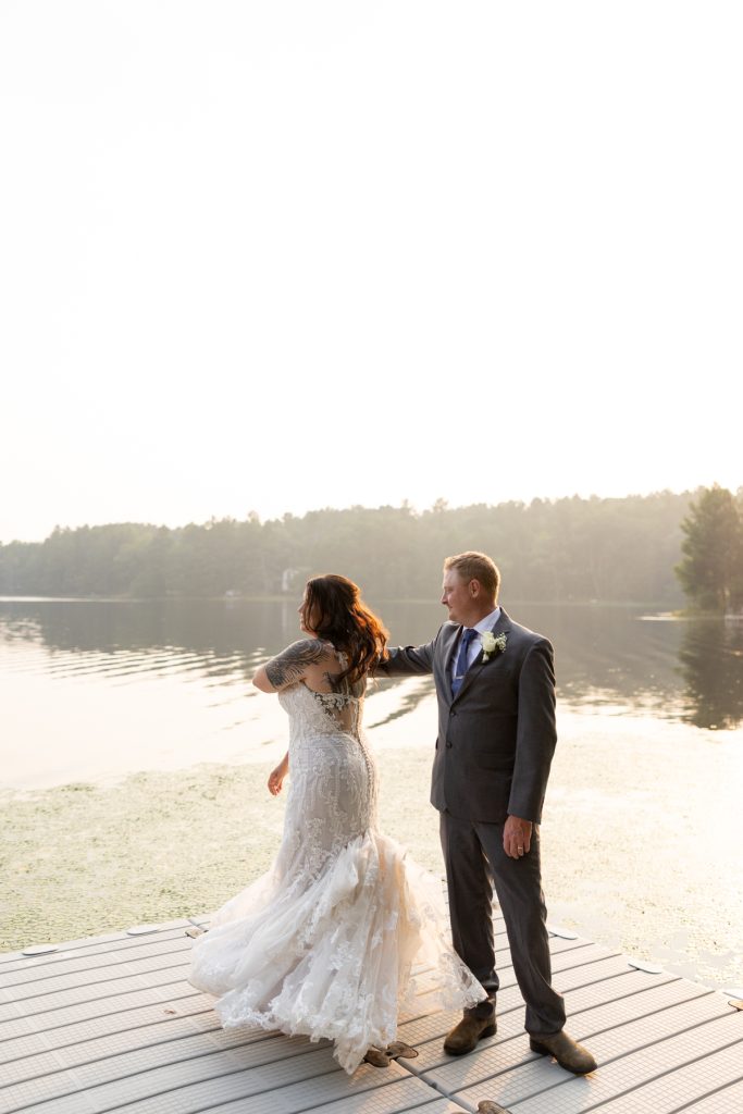 Bride and groom on dock at lake-side wedding in Hayward, WI