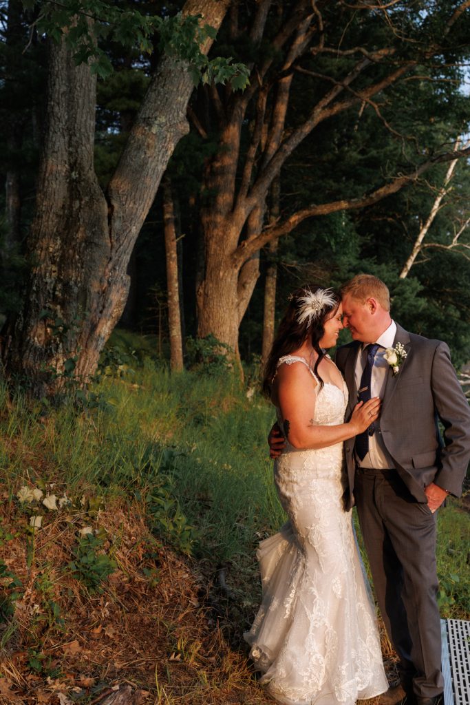 Bride and groom embracing in lakeside wedding portrait, Hayward, WI