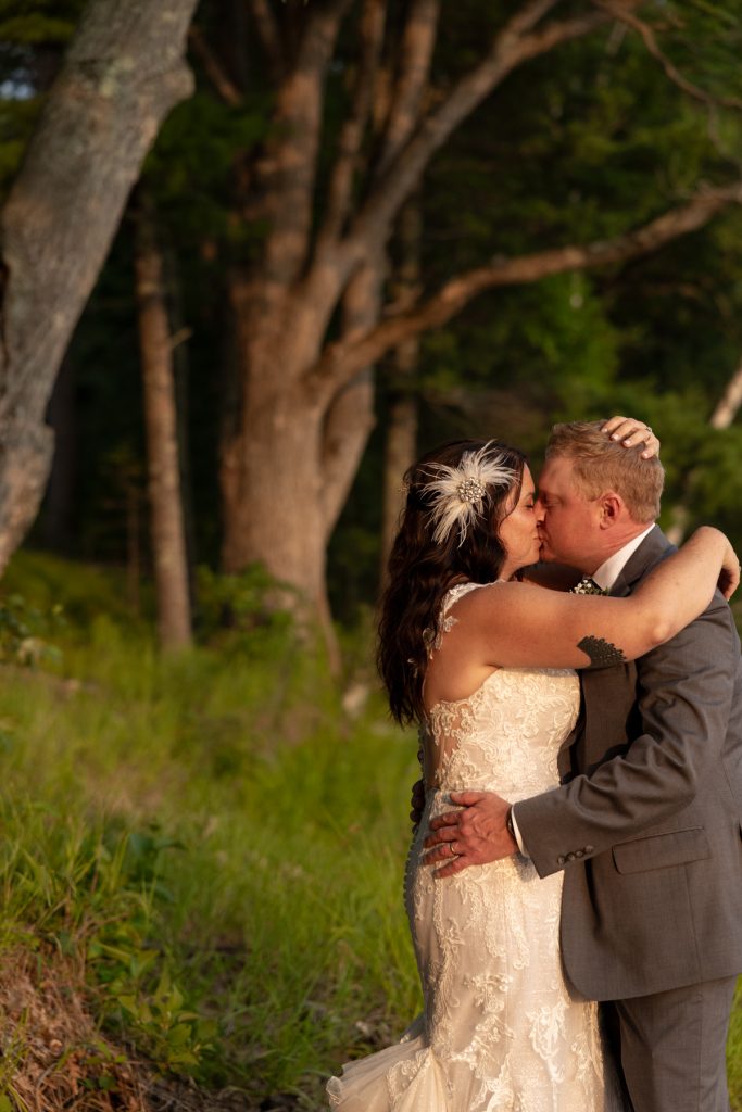 Bride and groom kissing lakeside at Hayward, WI wedding.