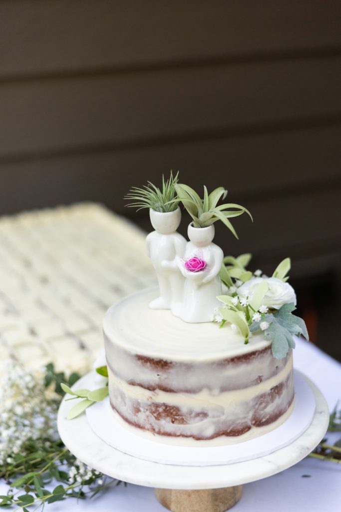 Wedding cake topper couple and floral decorations on a rustic cake at a Hayward, WI