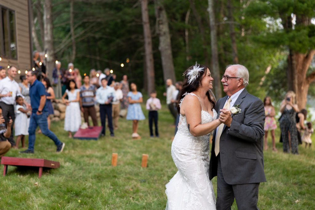Bride and groom dancing at backyard wedding in Hayward, WI, surrounded by guests and string