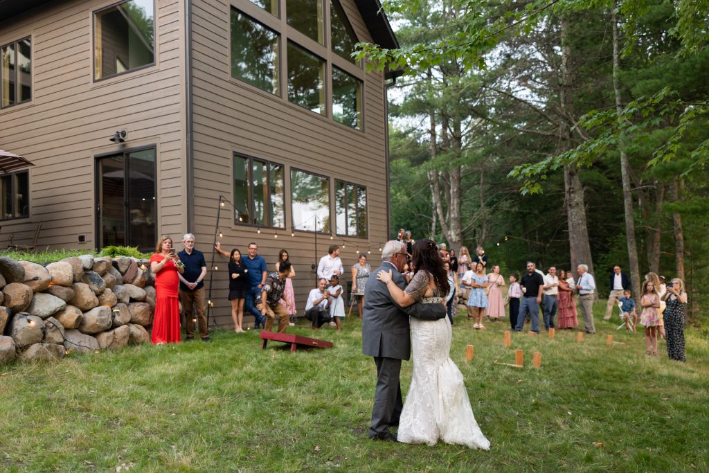 Bride and groom embracing at lakeside cabin wedding in Hayward, WI.