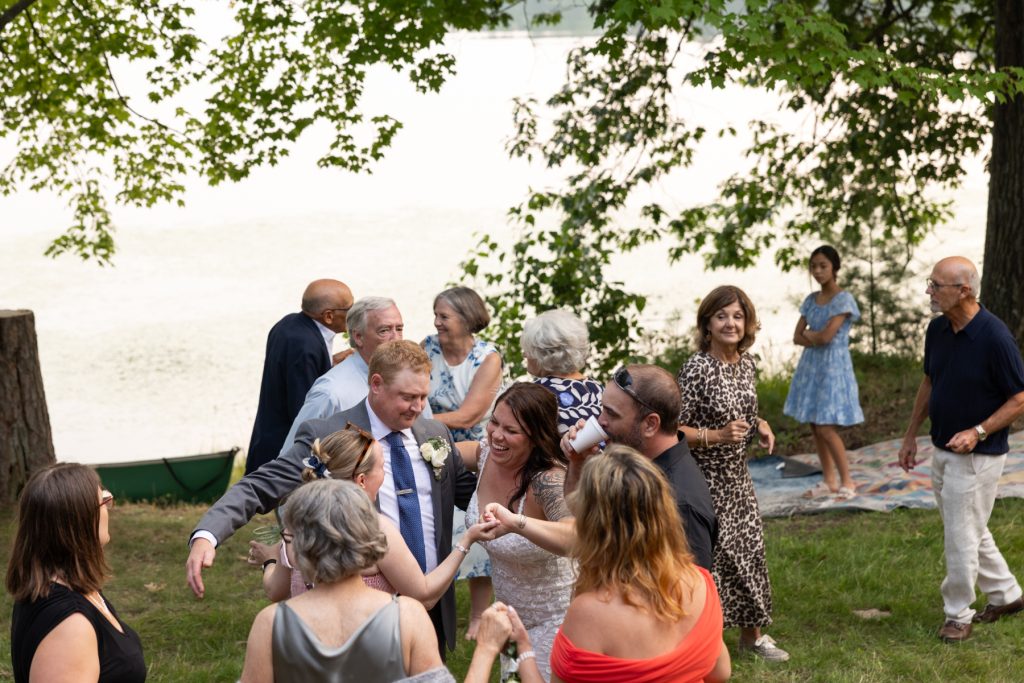 Bride and groom celebrating with family and guests at a lakeside wedding in Hayward, WI.