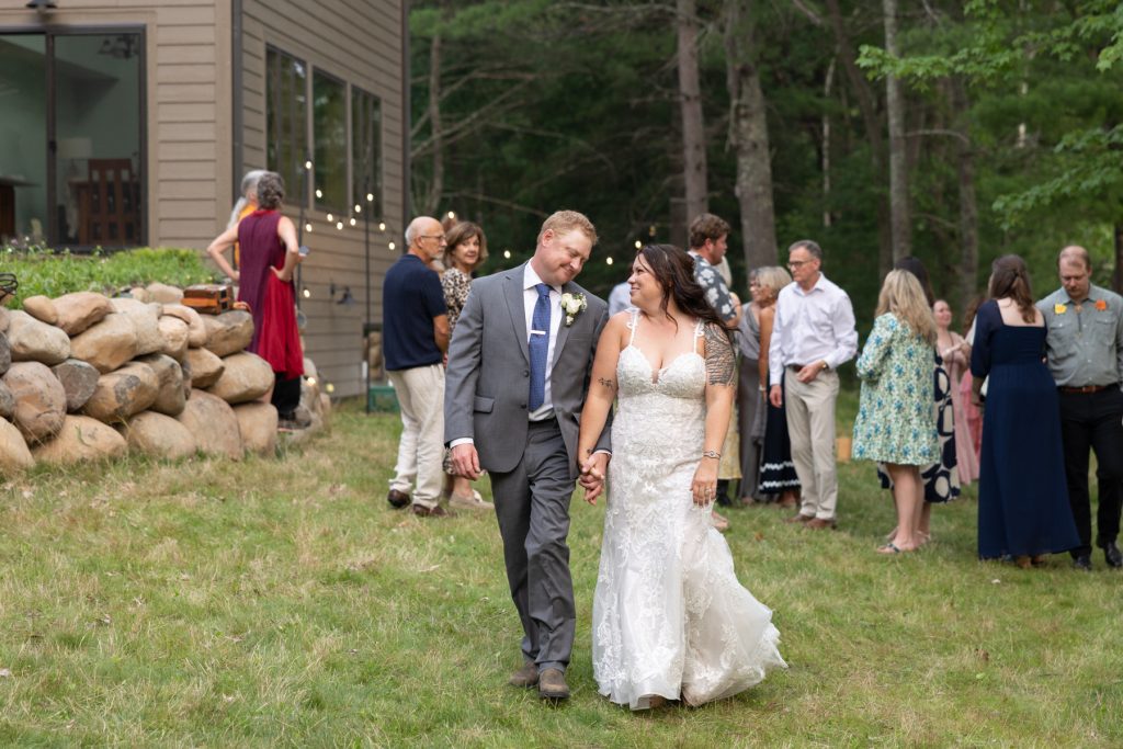 Bride and groom holding hands at a lakeside wedding in Hayward, WI.