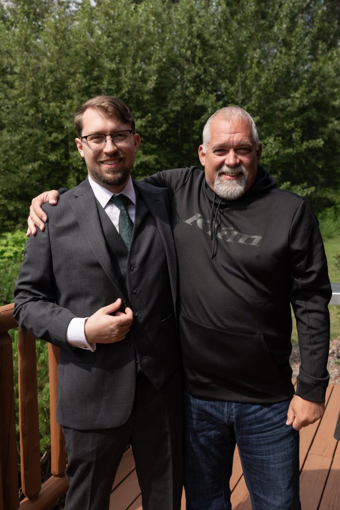 Two smiling men posing for a wedding photography portrait near Hayward, Wisconsin, one