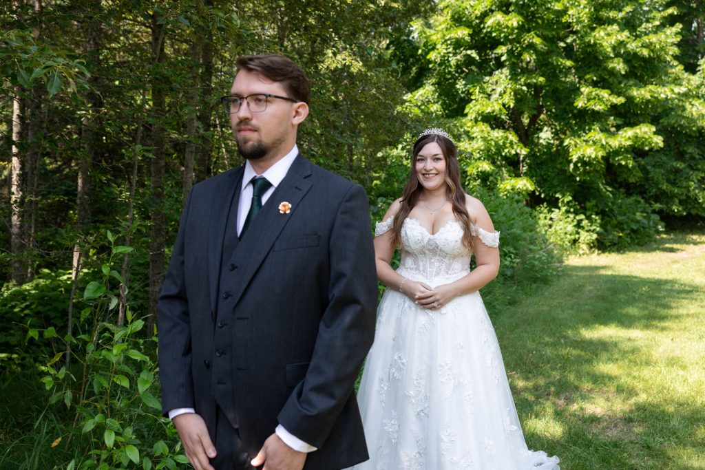 Bride and groom sharing an emotional first look amidst lush greenery in Hayward, Wisconsin, captured