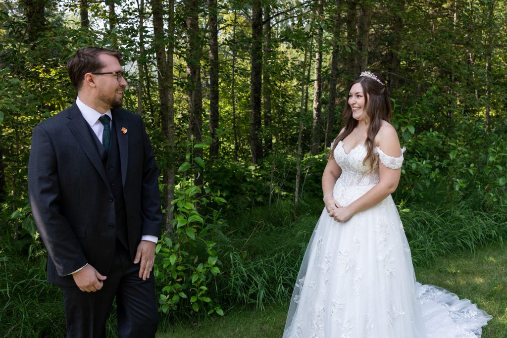 Bride in a flowing wedding gown and groom in a suit share a joyful first