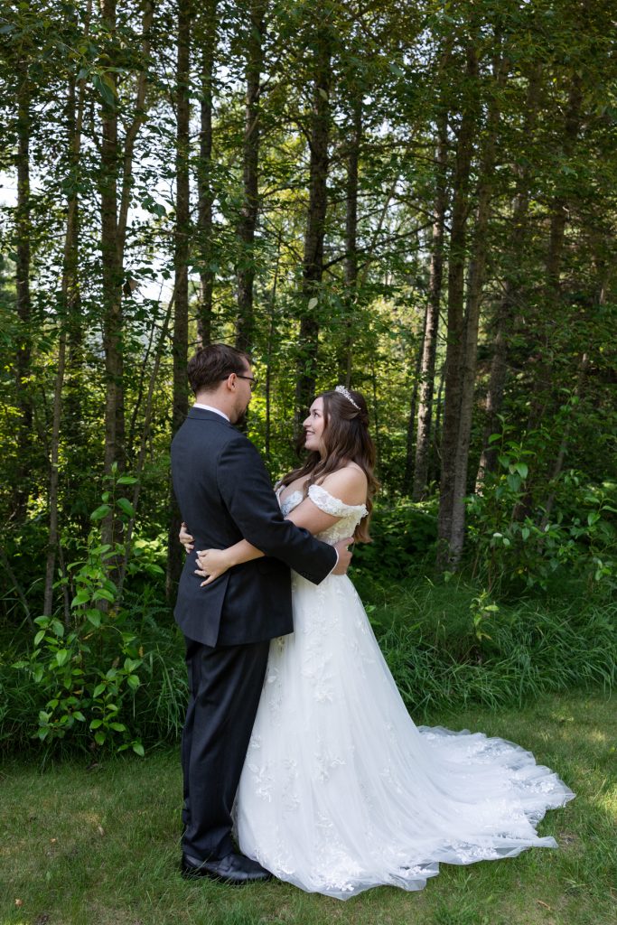 Bride and groom embracing in a wooded setting, showcasing wedding photography services in Wisconsin