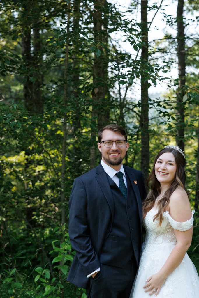 Newly married couple posing for wedding photography in a wooded setting near Hayward, Wisconsin, showcasing