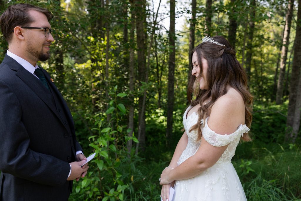 Bride and groom share an emotional first look in a wooded setting, captured by Beau