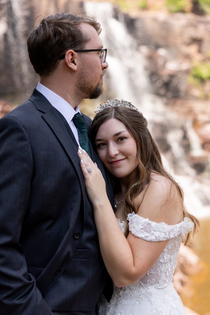 Newly married couple embracing near a waterfall, captured by Beau Petersen Photography, showcasing Wisconsin wedding