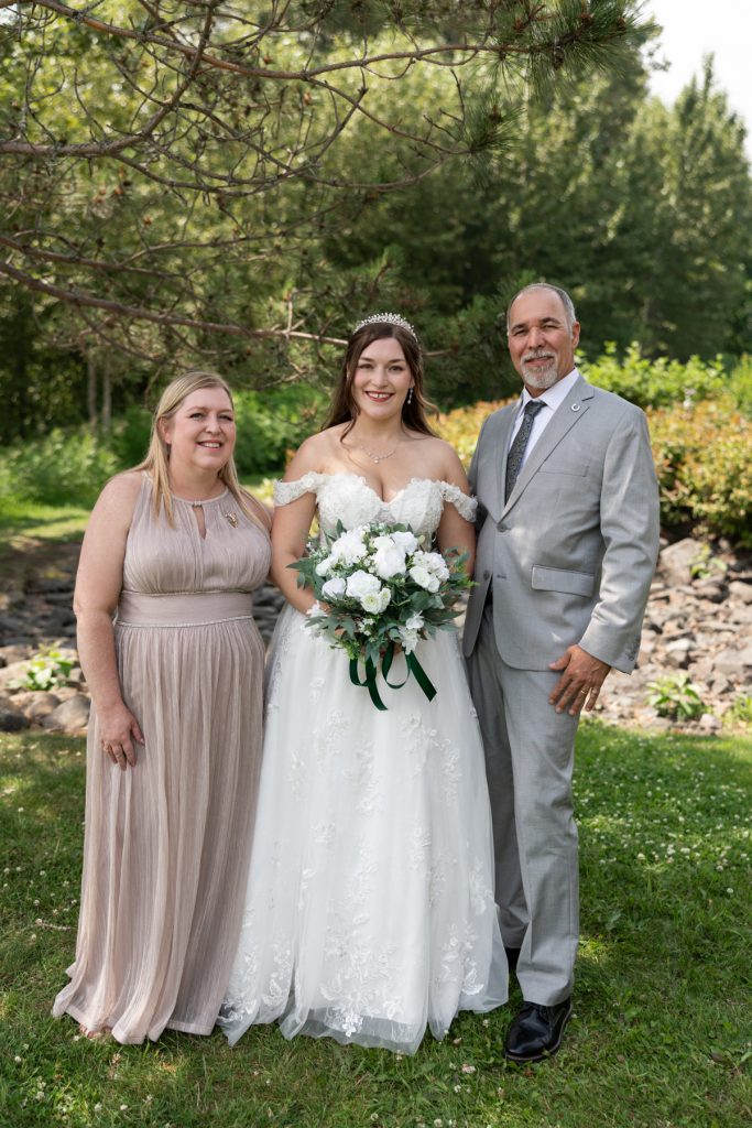 Bride and family posing for wedding photography in Wisconsin, featuring a bride in a white