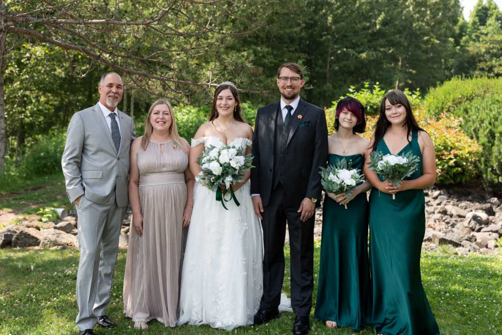 Bride and groom with family and wedding party in outdoor Wisconsin wedding photography portrait.