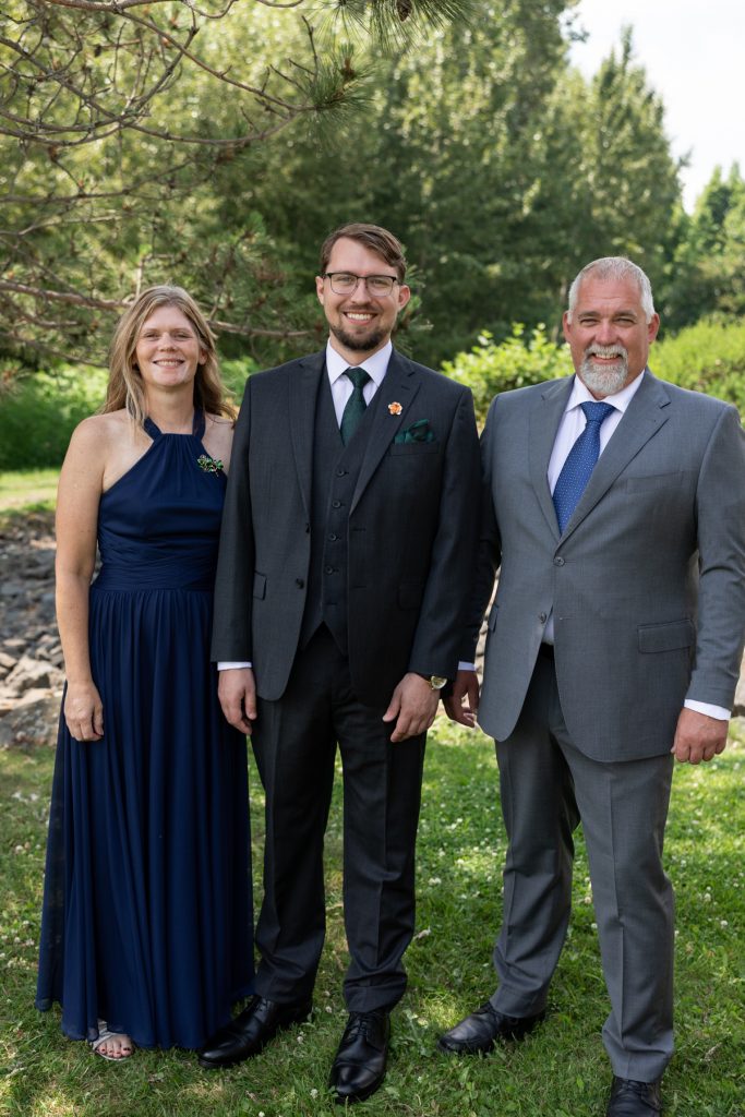 Three formally dressed wedding party members posing for a portrait in Hayward, Wisconsin, showcasing Beau