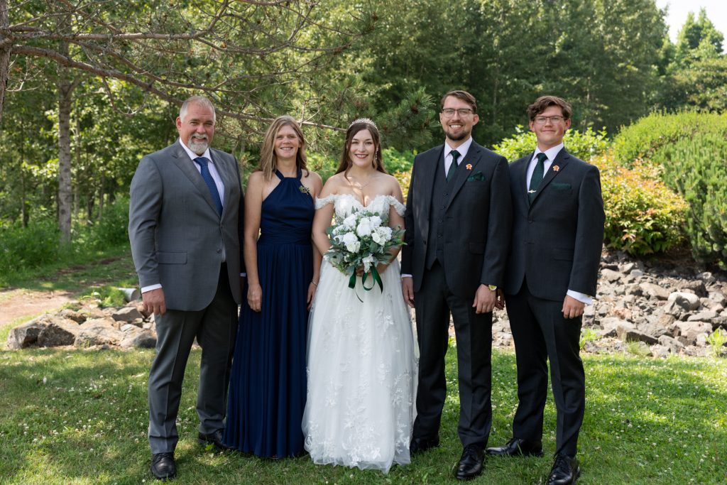 Formal wedding portrait of a family group including the groom and his parents, captured
