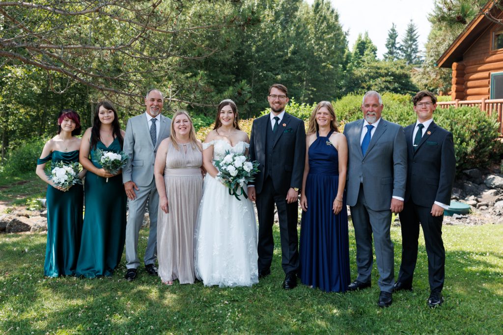Wedding party group portrait featuring the bride, bridesmaids, and groomsmen posing outdoors in Wisconsin, captured