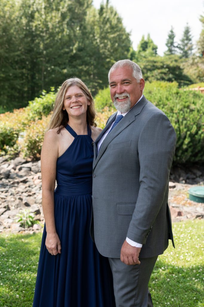 Couple smiling and posing for a wedding portrait in Hayward, Wisconsin, captured by Beau Petersen