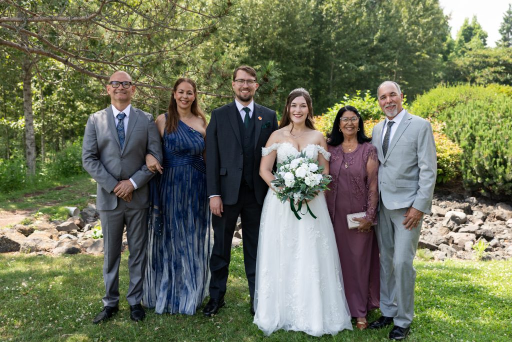 Bride and groom pose with family during wedding photography session in Wisconsin, captured by Beau