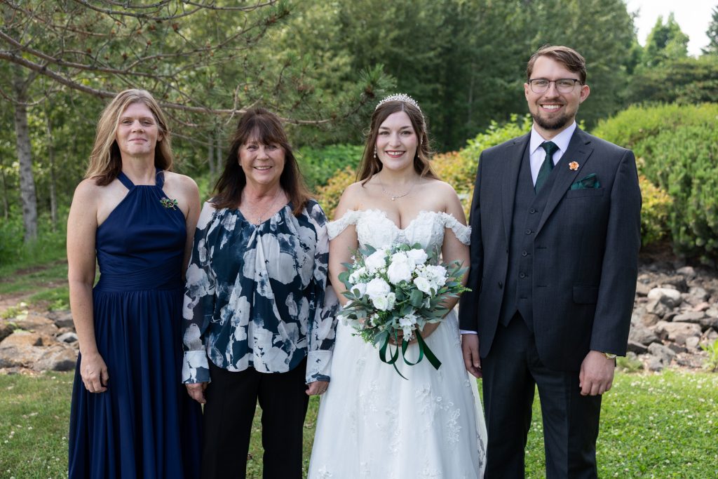 Bride and family posing for a wedding portrait in Hayward, Wisconsin, showcasing Beau Petersen Photography's