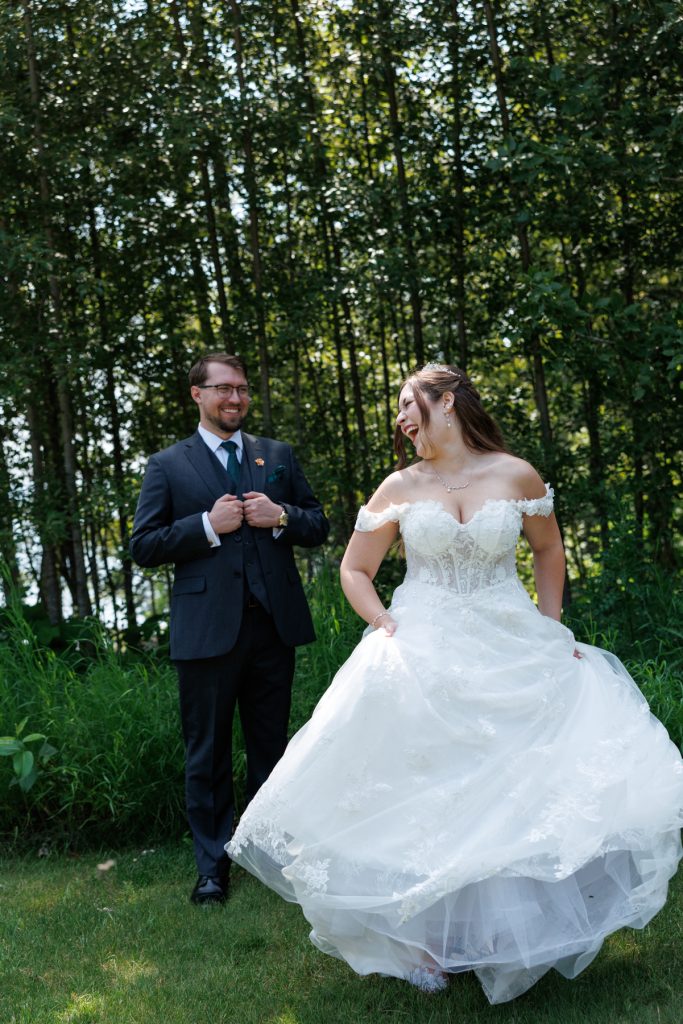 Bride and groom joyfully spinning in a field of tall grass during their wedding day