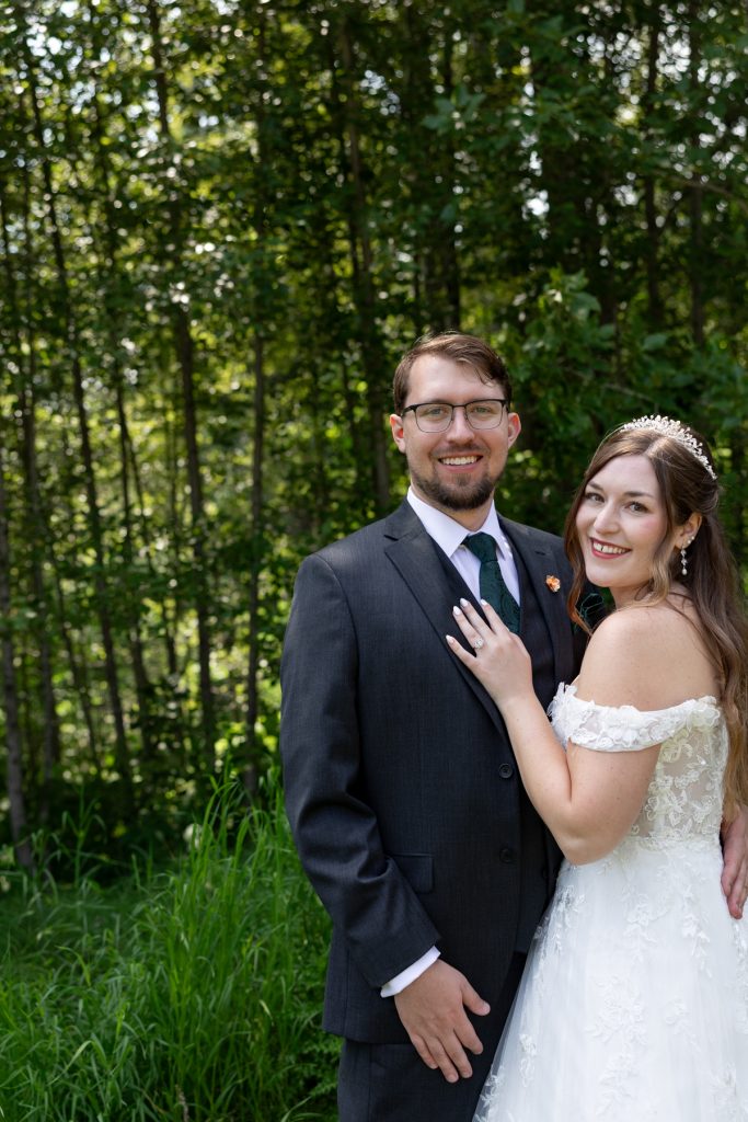Newly married couple posing for wedding photography in a wooded setting near Hayward, Wisconsin, showcasing