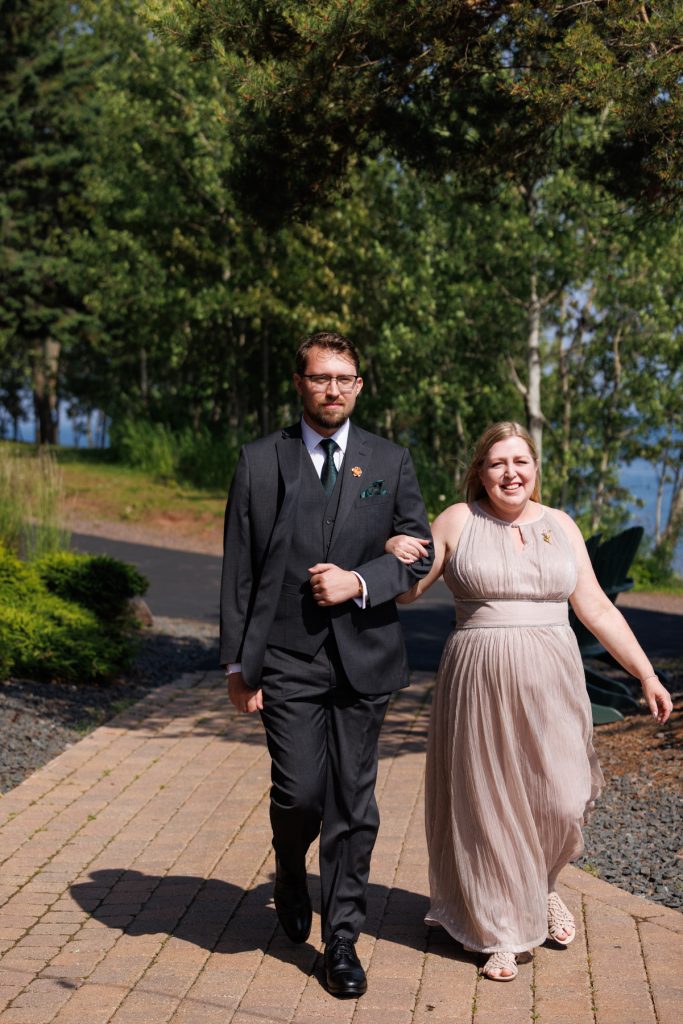 Newly married couple walking along a paved path during their wedding day, showcasing Wisconsin